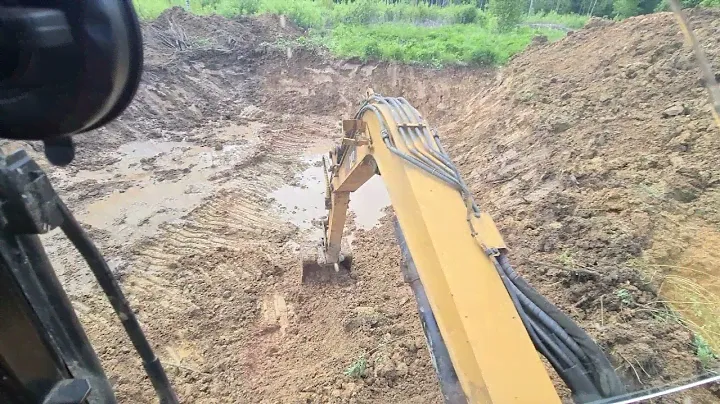 Миниэкскаватор CATERPILLAR копает озеро